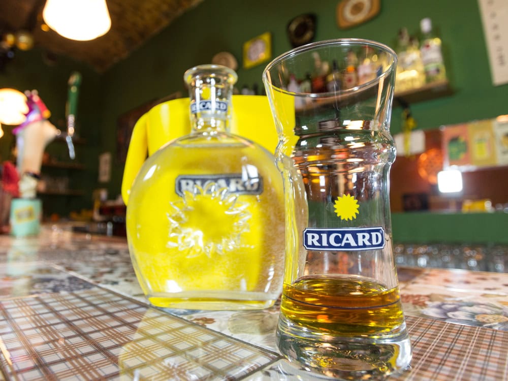 Close of on a Ricard jug and a water bottle with its logo. Ricard is a pastis, an anise and licorice flavored aperitif typical from Southern France
